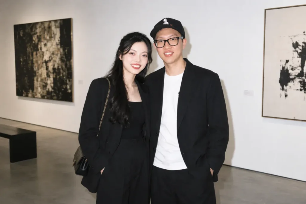 Gemini Couple Photo Prompts example of a couple standing together in a white-walled art gallery in a hard-flash portrait
